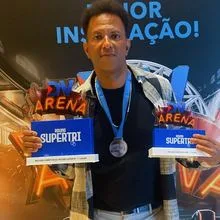 Cláudio Gomes segurando os troféus de campeão de vendas