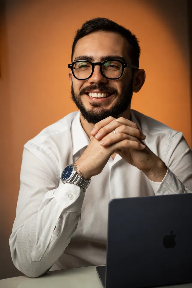 Higor Belini, CEO e fundador da Forus, sorrindo com as mãos apoiadas