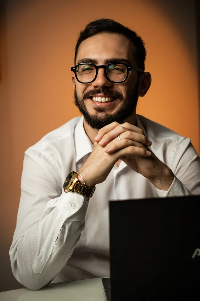 Higor Belini, CEO e fundador da Forus, sorrindo com as mãos apoiadas